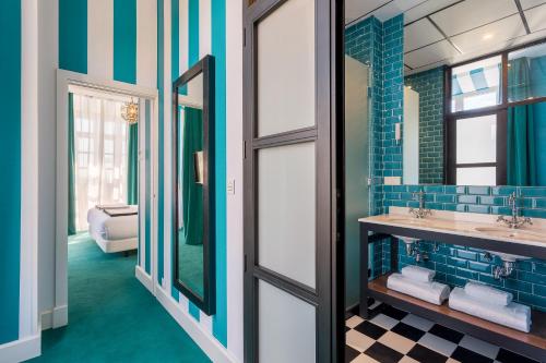 a bathroom with two sinks and a mirror at Room Mate Collection Valeria, Málaga in Málaga