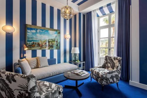 a living room with blue and white striped walls at Room Mate Collection Valeria, Málaga in Málaga