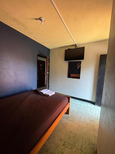 a bedroom with a bed and a flat screen tv at Panamá Hostels Inn in David