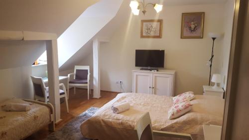 a bedroom with a bed and a tv in a attic at Willa Pod Basztą Restauracja&Wellness in Kazimierz Dolny