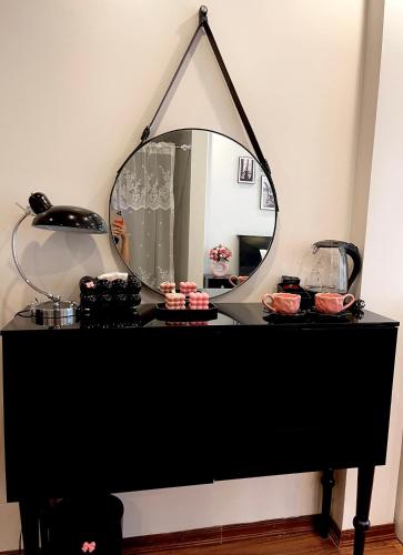 a mirror on top of a black table with cupcakes at C&K Premier Apartment Hai Phong in Hai Phong