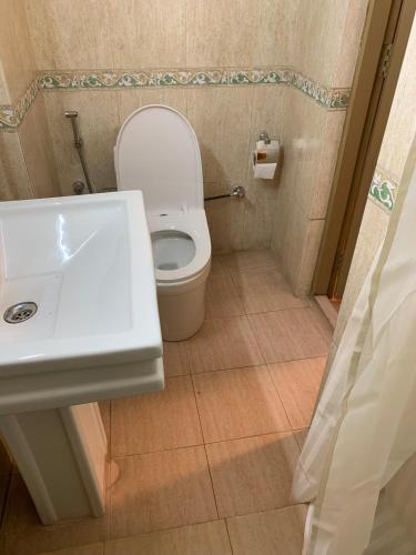 a bathroom with a white toilet and a sink at Kazi Resort & Hotel in Rājābāri