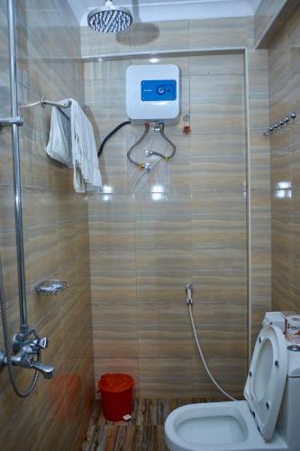 un bagno con doccia e un WC con tubo flessibile di Elanacha Hotel ad Arusha