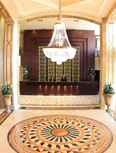 a large lobby with a chandelier and a large rug at Pyramisa Suites Hotel Cairo in Cairo