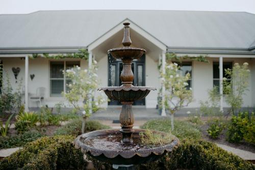 a fountain in the front yard of a house at Domaine du Moine in Oakhampton