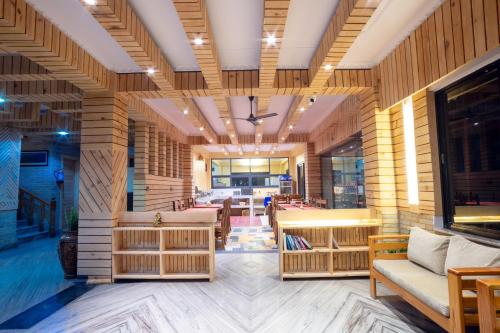 a lobby with wooden walls and tables and chairs at Trekkers Inn Boutique Hotel Pokhara in Pokhara