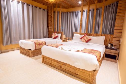 a hotel room with two beds and curtains at Trekkers Inn Boutique Hotel Pokhara in Pokhara