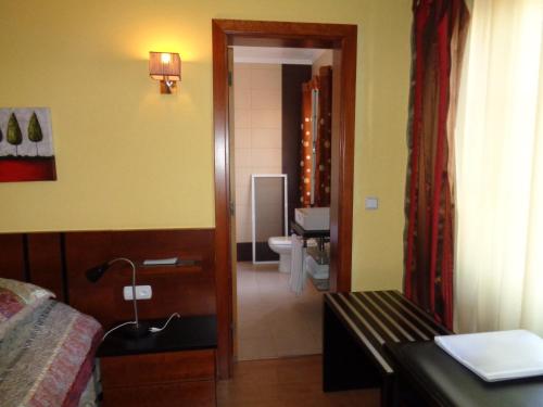 a bedroom with a bed and a bathroom with a toilet at Casa Das Faias in Santa Cruz da Graciosa