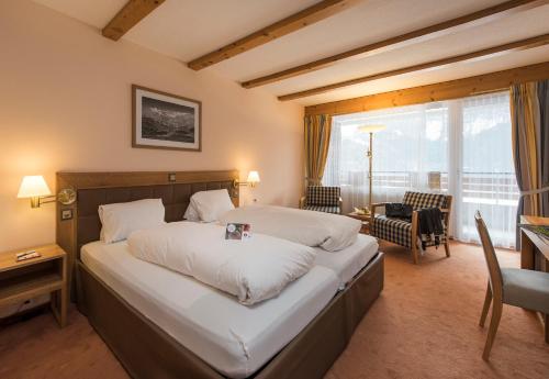 Un pat sau paturi într-o cameră la Sunstar Hotel & SPA Grindelwald
