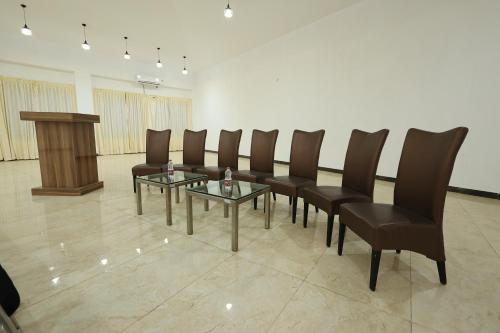 a conference room with leather chairs and a podium at Aaditya Greens Near Nelaguli Panchyat Office in Kaglipur