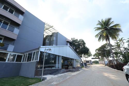 a building with a palm tree next to a street at Aaditya Greens Near Nelaguli Panchyat Office in Kaglipur
