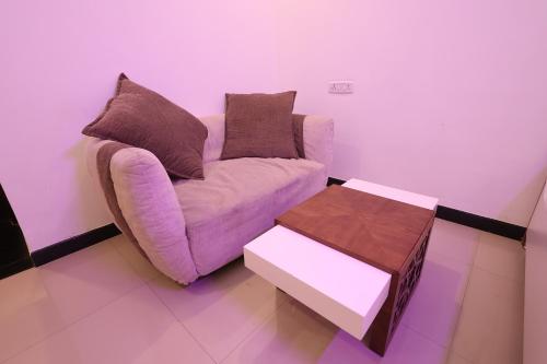 a living room with a purple couch and a table at Aaditya Greens Near Nelaguli Panchyat Office in Kaglipur