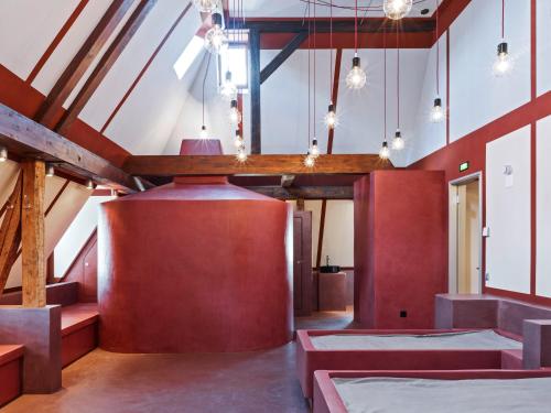 チューリッヒにあるAlma Hotelの赤い壁と木製の梁があるダイニングルーム