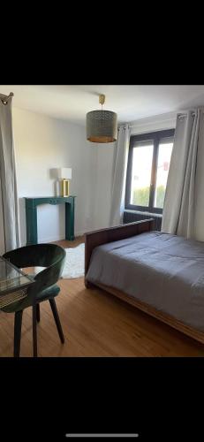 une chambre avec un lit, une chaise et une fenêtre dans l'établissement Maison familiale 4 Chambres, à Villeneuve-sur-Lot