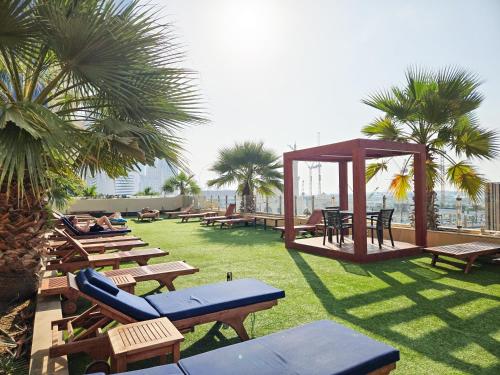 a park with benches and a gazebo and palm trees at Fabulous 1BR in Dubai Marina near Beach With Sea Views in Dubai