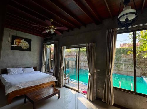 a bedroom with a bed and a view of a pool at Modern Thai Style Villa & Pool in Pattaya Central