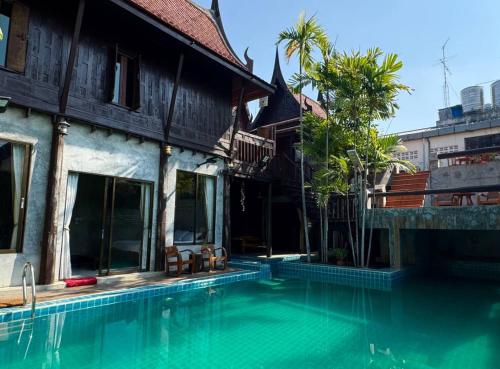 a swimming pool in front of a building with a house at Modern Thai Style Villa & Pool in Pattaya Central