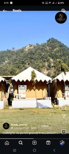 a picture of a house with a palm tree in front of it at Amrah Resort in Bairāgarh