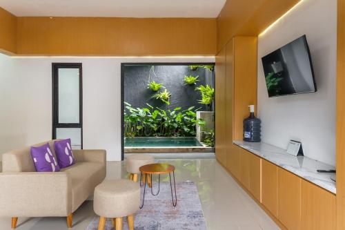 a living room with a fish tank in the window at INNCA Amerta Villa, Solo in Solo