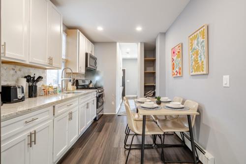a kitchen with white cabinets and a table with chairs at Jersey Haven NYC Next Door - Single car FREE PARKING in Fairview