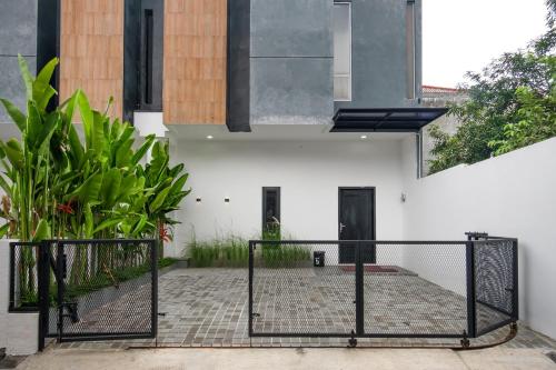 a gate in front of a white building with plants at INNCA Amerta Villa, Solo in Solo