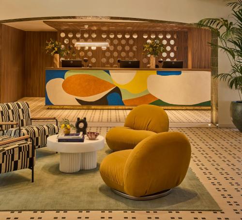 a lobby with yellow chairs and a table at Kimpton Los Monteros Marbella by IHG in Marbella