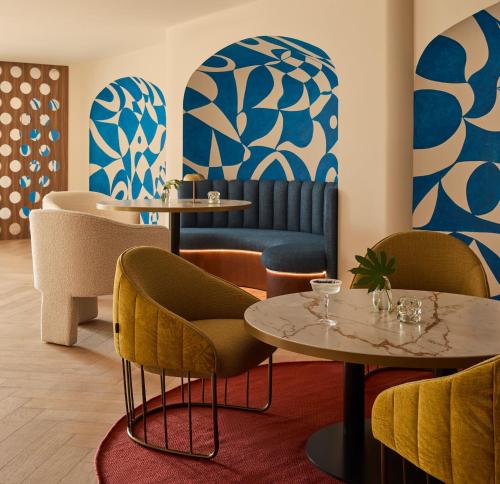 a restaurant with tables and chairs and blue and white vases at Kimpton Los Monteros Marbella by IHG in Marbella