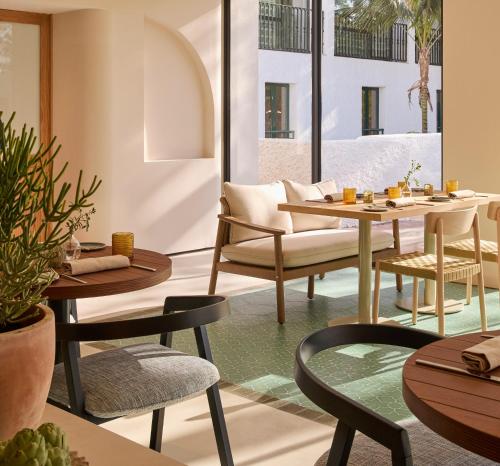 a restaurant with tables and chairs and a couch at Kimpton Los Monteros Marbella by IHG in Marbella