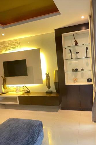 a room with a bed and a tv and shelves at Kamala Villa Hill in Kamala Beach