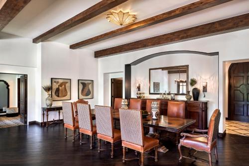 a dining room with a table and chairs and a mirror at Omni Scottsdale Resort & Spa at Montelucia in Scottsdale
