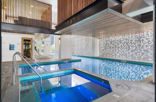 an indoor swimming pool with blue water in a building at River View Apartment South Brisbane in Brisbane
