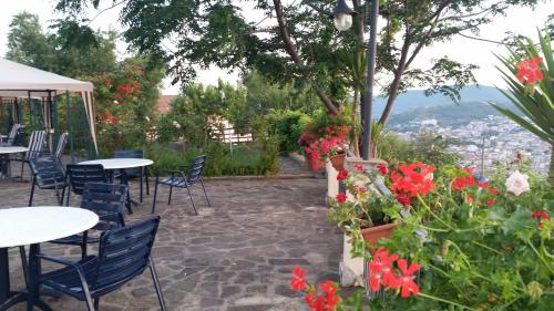 a patio with tables and chairs and flowers at Villa Malandrino Guest House in Agropoli