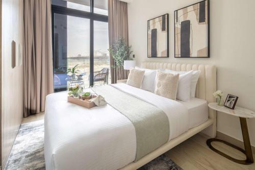 a bedroom with a large white bed with a window at Frank Porter - Azizi Riviera 1 in Dubai