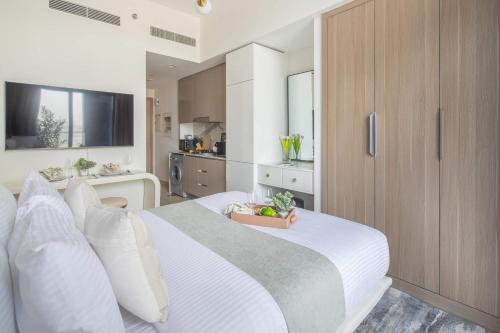 a bedroom with a white bed with a bowl of fruit on it at Frank Porter - Azizi Riviera 1 in Dubai