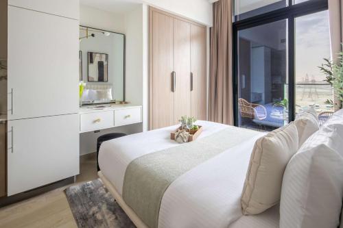 a bedroom with a large white bed and a window at Frank Porter - Azizi Riviera 1 in Dubai
