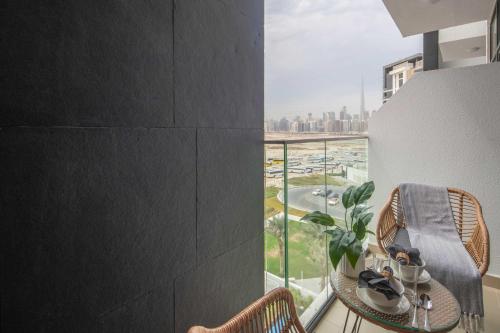 a balcony with a table and chairs and a view of the city at Frank Porter - Azizi Riviera 1 in Dubai