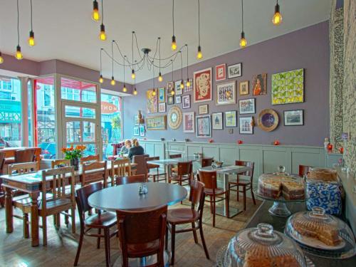 a restaurant with tables and chairs and people in the background at Monties Guest House - Adults ONLY in Bowness-on-Windermere