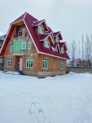a house with a red roof in the snow at Al Jalal Resort in Srinagar