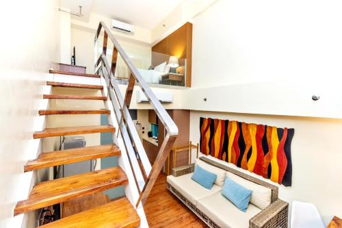 a living room with a staircase and a couch at Ferra Premier by JG in Boracay
