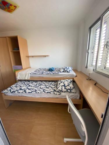 ein kleines Schlafzimmer mit zwei Betten und einem Schreibtisch in der Unterkunft EstrellaMar in Arinaga