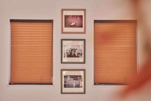 a wall with two windows with pictures on it at Aqua Villa with Pool, Sauna, and 100 inch 4K Projector, 5-minute walk from Fujitsu Park Sea in Futtsu