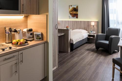 um quarto de hotel com uma cama e uma cozinha em SVG Boardinghaus em Munique