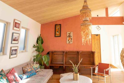 a living room with a couch and a table at Aqua Villa with Pool, Sauna, and 100 inch 4K Projector, 5-minute walk from Fujitsu Park Sea in Futtsu
