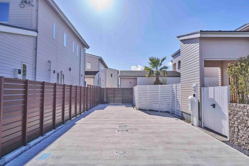 a driveway between two buildings with a fence at Aqua Villa with Pool, Sauna, and 100 inch 4K Projector, 5-minute walk from Fujitsu Park Sea in Futtsu