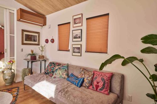 a living room with a couch with pillows on it at Aqua Villa with Pool, Sauna, and 100 inch 4K Projector, 5-minute walk from Fujitsu Park Sea in Futtsu