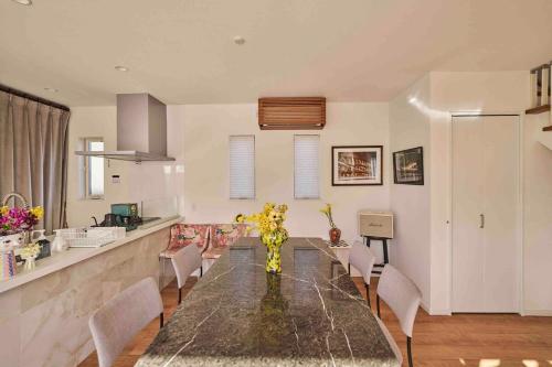 a kitchen and dining room with a table and chairs at Aqua Villa with Pool, Sauna, and 100 inch 4K Projector, 5-minute walk from Fujitsu Park Sea in Futtsu