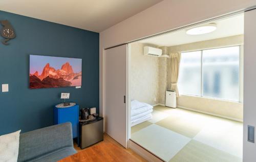 a bedroom with blue walls and a sliding glass door at Flower Base Lily House - Vacation STAY 55464v in Fukuoka