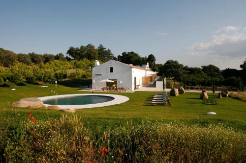 een wit huis met een zwembad in de tuin bij Imani Country House in Évora