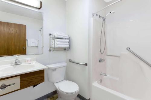 a white bathroom with a toilet and a shower at Super 8 by Wyndham Antigo in Antigo