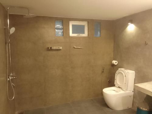 a bathroom with a white toilet and a shower at Villa28 Habaraduwa in Habaraduwa